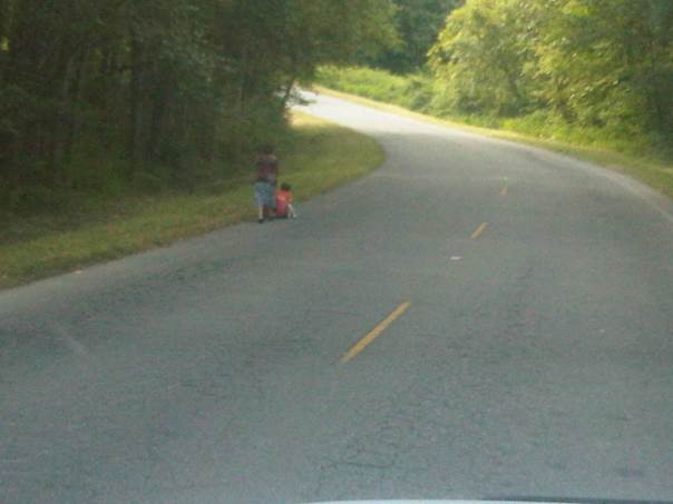 Mother pushing baby stroller on Hollyhills Dr